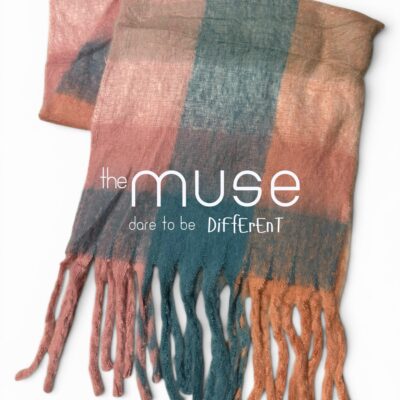 An oversized blanket scarf featuring large color blocks in terracotta, peach, charcoal, and teal, with thick, chunky fringe tassels in matching earthy tones.